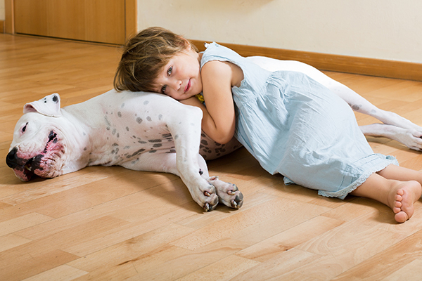 little girl laying on dog with lip quivers signs of stress or a bite