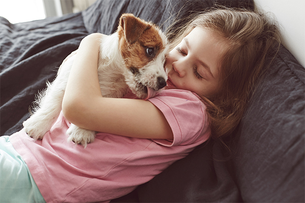 little girl holding a dog showing signs of aggression
